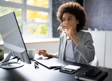 Une femme boit de leau au bureau 360x260